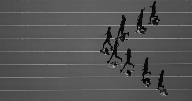 A fleet of runner running together on a race track